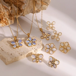 Golden butterfly jewelry set with natural stones and zircons displayed on natural rock