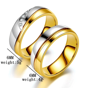Close-up of two-tone stainless steel couple rings showing 6mm width and diamond inlay