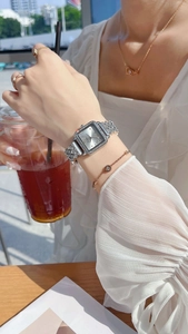 Close-up of elegant square silver watch with rhinestones on female model wrist
