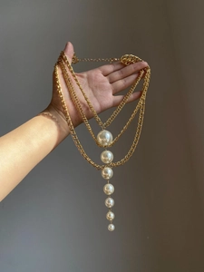 Detail view of multi-layer chunky gold chain necklace with gradient white pearls