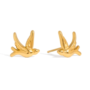 Macro shot of gold bird earrings showing 18K stainless steel texture and fine wing detail