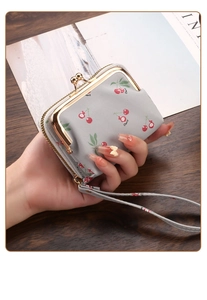 Detail of gray cherry pattern wallet with golden kiss lock and leather wrist strap