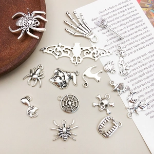 Detail of vintage silver Halloween charms including spiders and skulls for jewelry making