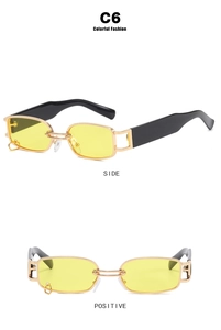 Detail of vintage square sunglasses with gold metal frame, yellow lenses and ring charm