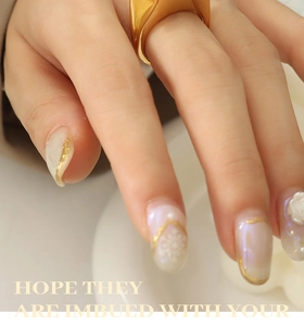 Close-up of a Y-style 18k gold-plated ring with pearl nail art and floral relief details