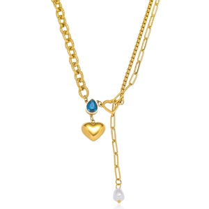 Golden necklace with blue teardrop gemstone, heart pendant, pearl tassel and chain detail