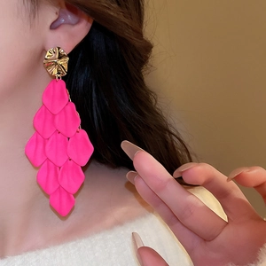 Close-up of pink acrylic petal tassel earrings with gold irregular metal top on a model