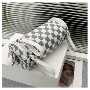 Detail of cylinder crossbody bag featuring grey checkerboard pattern and wide white strap