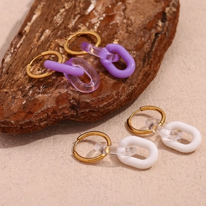 Dettaglio di orecchini a cerchio placcati oro con maglie in acrilico viola e bianco alla moda