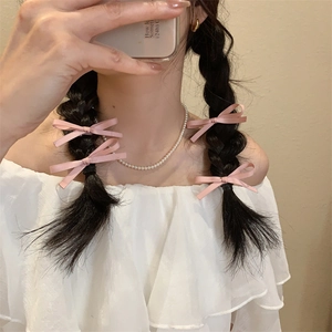 Roze satijnen strik haarspeldjes en parelketting voor een Franse zoete modieuze look