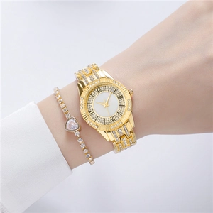 Close-up of gold watch with rhinestones and heart bracelet on a woman's wrist