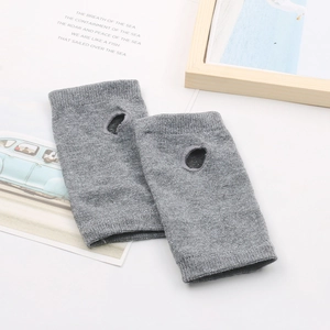 Vue détaillée de mitaines en tricot gris avec texture fine sur un bureau blanc épuré