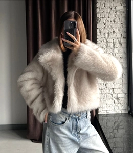 Detail of faux fox fur coat with large lapels in cream white faux fur texture