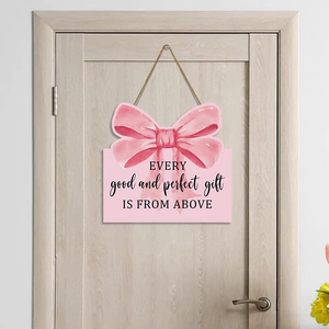 Pink wooden bow door sign with inspirational quote hanging on a wooden bedroom door