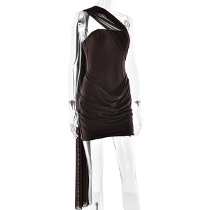 Detail of dark brown one-shoulder mini dress featuring pleated fabric and a long tulle sash