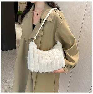 Elegante borsa a spalla in peluche bianca indossata da una modella in stile street chic