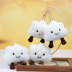 Close-up of cute white cloud plush keychains with embroidered smiling faces and silver ball chains