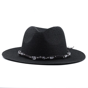 Close-up of black straw fedora hat featuring a beaded decorative band with silver accents