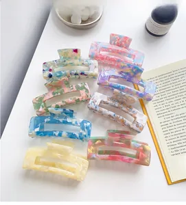 Flat lay of large acetate hair claws in various floral and marble patterns on a white table
