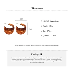 Macro view of C-shape resin hoop earrings with amber texture and 3x2cm size specs