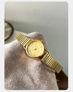 Close-up of GEDI women's gold quartz watch with a champagne dial and metallic elastic band