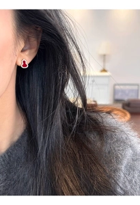 Close-up of red agate gourd earrings with sparkling zircons on model ear