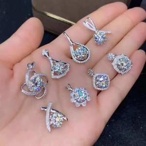 Variety of sparkling moissanite diamond pendants in silver finish held in hand