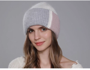 Dettaglio di un berretto da donna in maglia con design a blocchi grigio, bianco e rosa