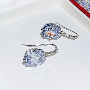 Macro detail of silver drop earrings with faceted oval crystals and paved stone hooks