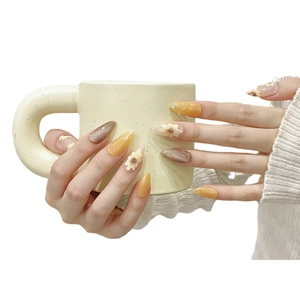 Handmade almond press-on nails with yellow sunflower designs and cat-eye glitter finish