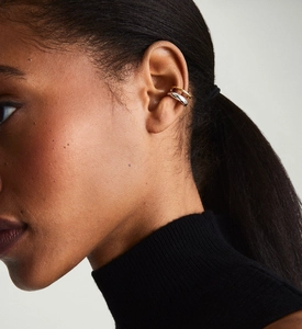 Close-up of double-layered gold and silver ear cuffs worn on a model ear