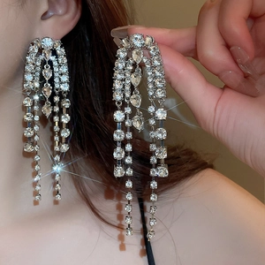 Detailed view of silver long chain tassel earrings with sparkling rhinestones in motion