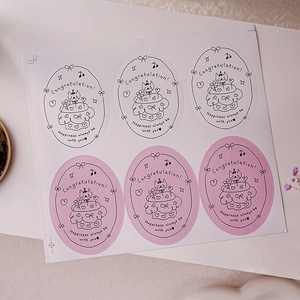 Detailed view of pink and white oval Happy Birthday stickers for gift sealing and packaging