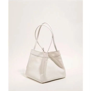 Dettaglio della borsa a secchiello bianca minimalista con texture in pelle a grana litchi