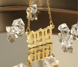 Macro detail of gold 999 number pendant with frosted texture and luxury reflections
