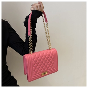 Close-up of pink quilted crossbody bag with gold chain strap and metal swivel lock
