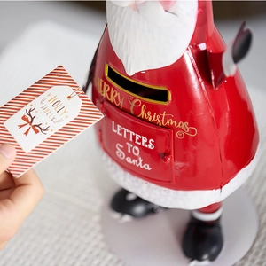 Red metal Santa mailbox with gold Merry Christmas text and slot for holiday letters