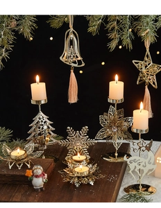 Close-up of golden metal Christmas candle holders with reindeer and snowflake ornaments