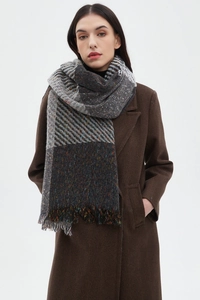 Detail of gray and brown tweed plaid scarf with frayed fringe edges on a model