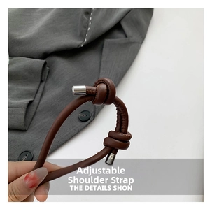 Detail of dark brown leather adjustable shoulder strap with knot design and metal buckle