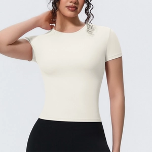 Gros plan du t-shirt de yoga crème montrant la texture fine du tissu et le col rond