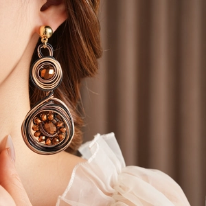 Detail of vintage woven round earrings with beads and wire texture on model
