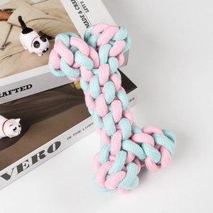 Detail eines rosa-blauen Baumwollseil-Knochen-Spielzeugs für Hunde auf weißem Grund