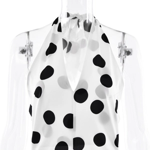 Detailed view of white backless halter top with black polka dots on transparent mannequin