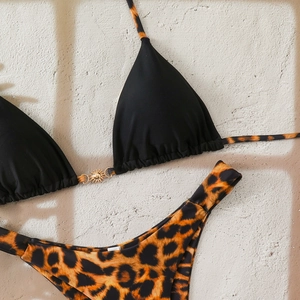 Detail of leopard print bikini with a golden sun metal buckle on black triangle cups