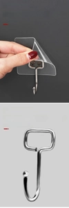 Close-up of thick solid metal hook with transparent self-adhesive backing for walls