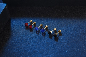 Detailed view of square zircon stud earrings in red, blue, and black with screw backs