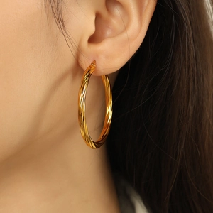 Elegant 18k gold plated stainless steel twisted hoop earrings worn by a model
