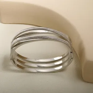 Polished silver multilayer stainless steel bangle with textured wire details and hinge
