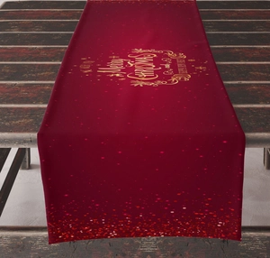 Detail of red Christmas table runner with gold Merry Christmas print on rustic wood